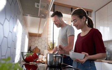 father and daughter making soup together