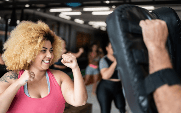 Woman smiling while taking a self defense class