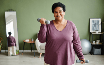 Woman exercising at home with dumbbells
