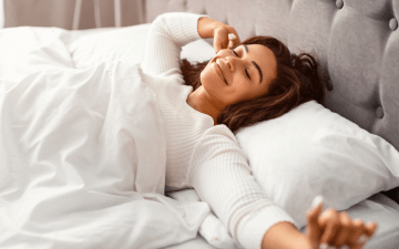 woman stretching in bed after restful sleep