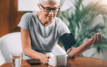Senior testing blood pressure with a cuff