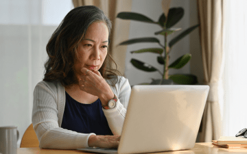 woman looking at computer contemplatively