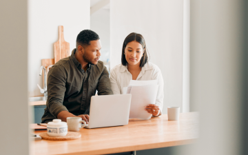 couple looking at a computer and papers