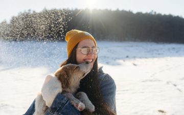 woman holding a dog outside in winter