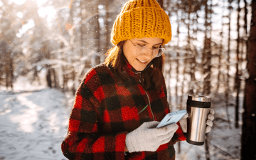 woman using her phone outside during winter