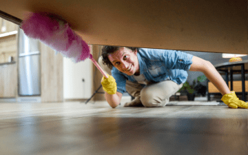Man dusting under a bed
