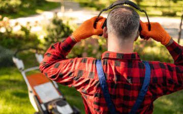 man putting on hearing protection before mowing lawn