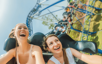 Two women riding roller coasters