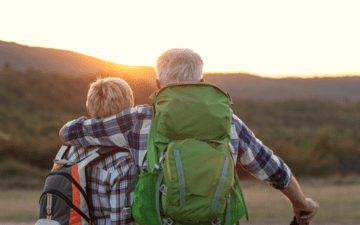 senior couple watching the sunrise over the mountains