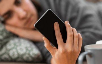 woman laying down holding a phone