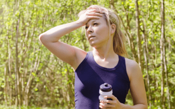 woman overheating after a walk while holding a water bottle