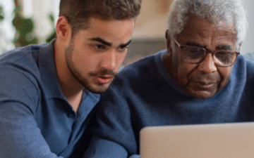 man helping his father use the computer