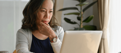woman looking at computer contemplatively
