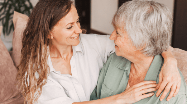 a mother and daughter embracing on a couch
