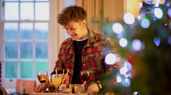 man serving non alcoholic festive drinks to his friends