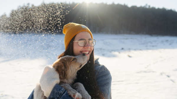 woman holding a dog outside in winter