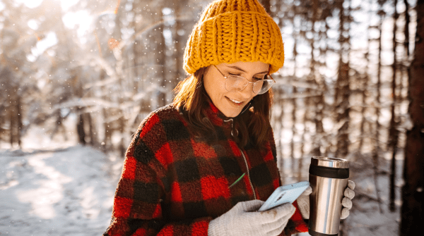 woman using her phone outside during winter