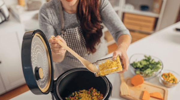 woman preparing a meal with a slow cooker