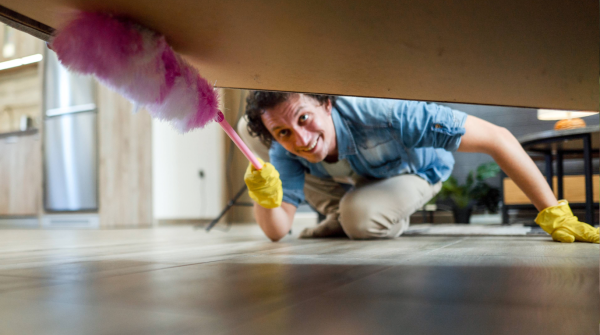 Man dusting under a bed