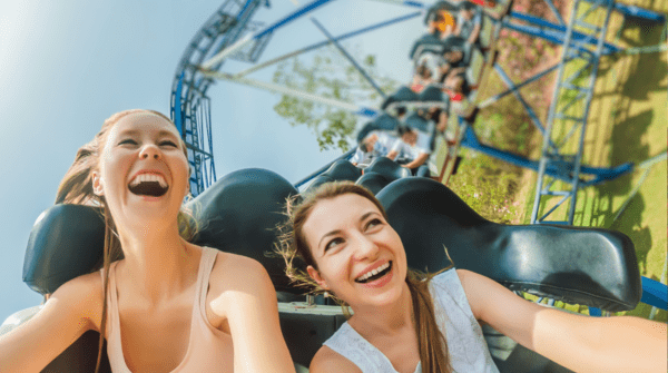 Two women riding roller coasters