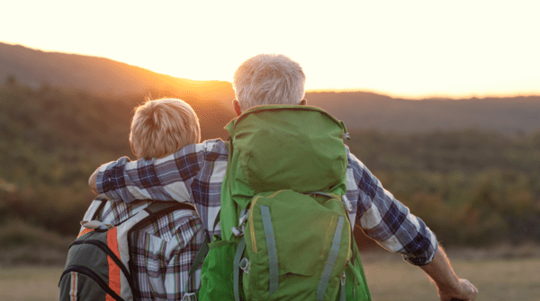 senior couple watching the sunrise over the mountains