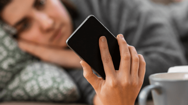 woman laying down holding a phone