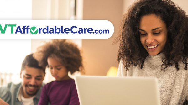 Woman looking at computer with family in background