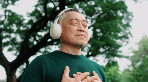 man meditating outside wearing headphones