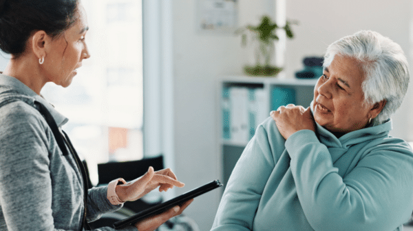 Woman speaking with a chiropractor about shoulder pain