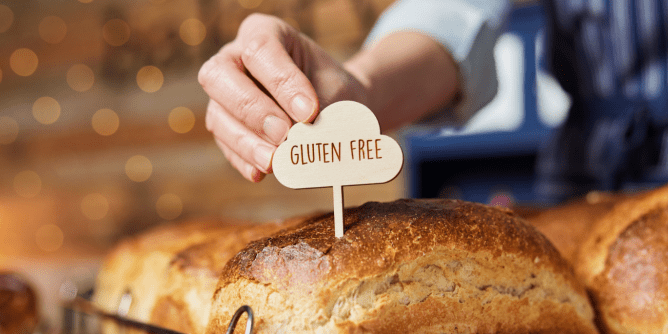 Baker placing a &quot;Gluten-Free&quot; sign on bread