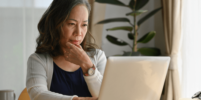 woman looking at computer contemplatively