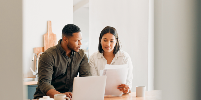couple looking at a computer and papers