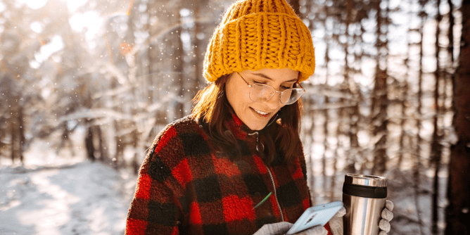 woman using her phone outside during winter