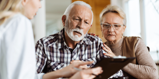 senior couple looking at clipboard