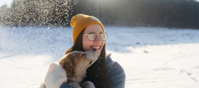 woman holding a dog outside in winter