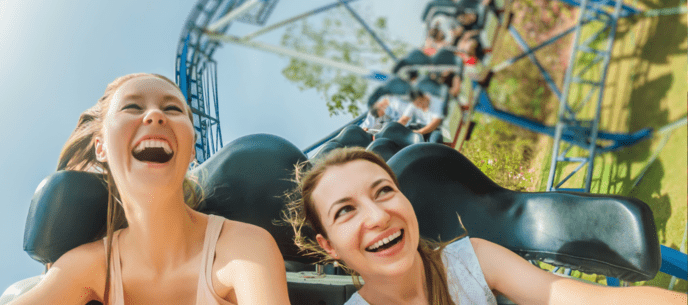 Two women riding roller coasters