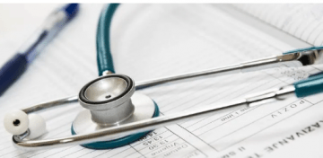 Stethoscope laying on paper forms