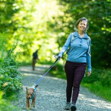 Woman walking her dog on a Vermont trail